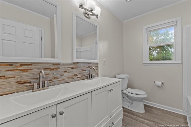 425 N Platte Rd, Fayetteville, NC 28303 - bathroom with crown molding, tasteful backsplash, double vanity, wood finished floors, and a tub to relax in