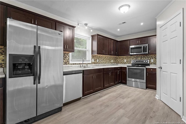 425 N Platte Rd, Fayetteville, NC 28303 - kitchen featuring appliances with stainless steel finishes, dark brown cabinetry, light countertops, decorative backsplash, and crown molding