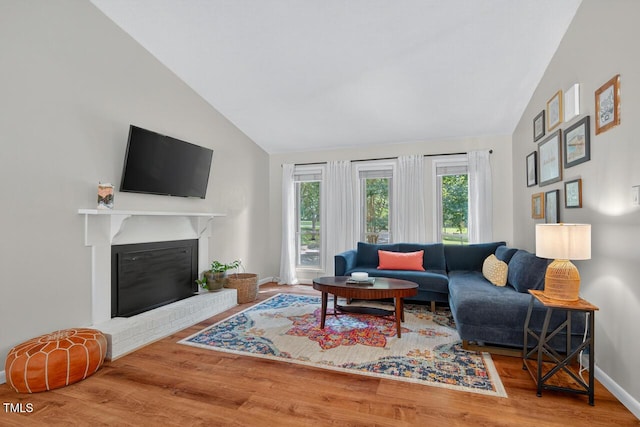 810 Royal Oaks Dr, Durham, NC 27712 - living room featuring lofted ceiling, wood finished floors, and a fireplace