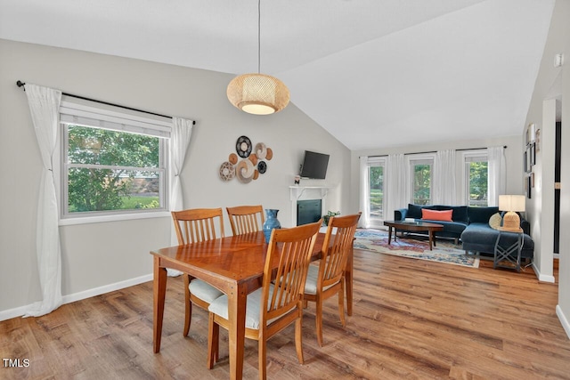810 Royal Oaks Dr, Durham, NC 27712 - dining room featuring vaulted ceiling, light wood-style floors, and a fireplace