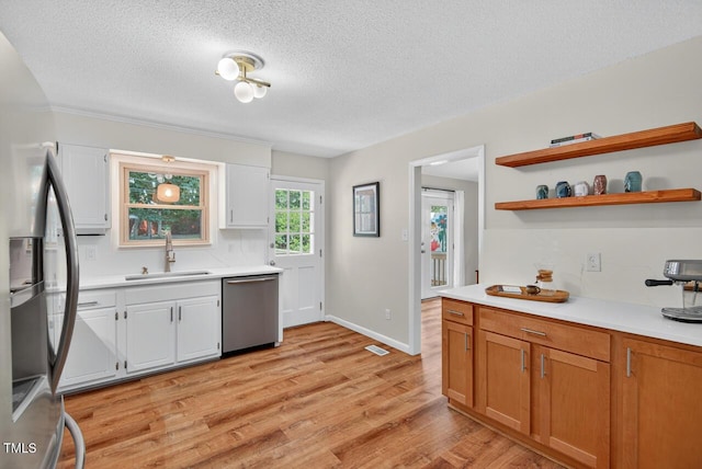 810 Royal Oaks Dr, Durham, NC 27712 - kitchen with stainless steel appliances, a textured ceiling, light countertops, light wood-type flooring, and open shelves