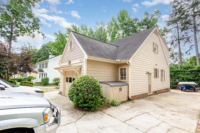 1408 Morningsdale Dr, Raleigh, NC 27609 - view of property exterior featuring a shingled roof, driveway, and a garage