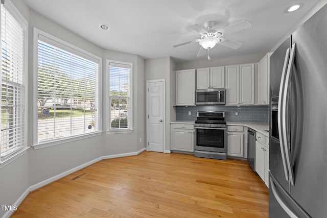400 Nottinghill Walk, Apex, NC 27502 - kitchen featuring appliances with stainless steel finishes, light countertops, backsplash, light wood-style flooring, and recessed lighting
