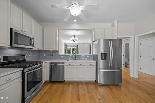 400 Nottinghill Walk, Apex, NC 27502 - kitchen featuring stainless steel appliances, light countertops, a chandelier, white cabinets, and decorative backsplash