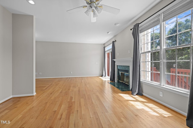 400 Nottinghill Walk, Apex, NC 27502 - unfurnished living room with light wood-style flooring, a high end fireplace, a ceiling fan, and recessed lighting