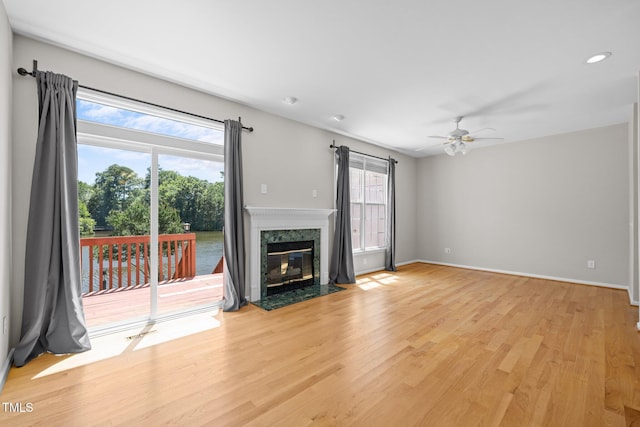 400 Nottinghill Walk, Apex, NC 27502 - unfurnished living room featuring ceiling fan, light wood-style floors, a premium fireplace, and recessed lighting