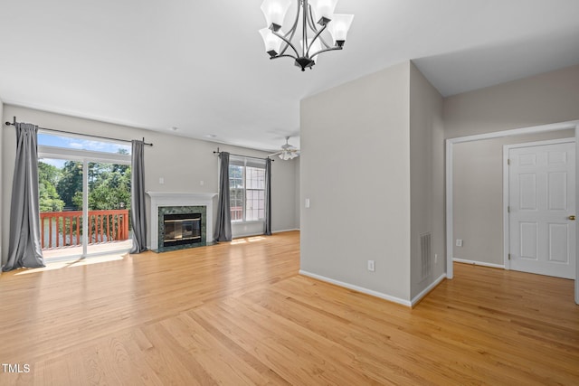 400 Nottinghill Walk, Apex, NC 27502 - unfurnished living room featuring a chandelier, light wood finished floors, and a premium fireplace