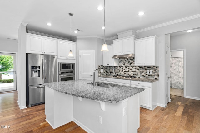 1019 Santiago St, Durham, NC 27703 - kitchen featuring appliances with stainless steel finishes, tasteful backsplash, light stone countertops, white cabinetry, and ornamental molding