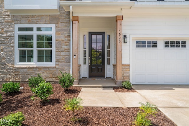 525 Kings Lake Way, Durham, NC 27703 - view of exterior entry featuring stone siding, a garage, and driveway