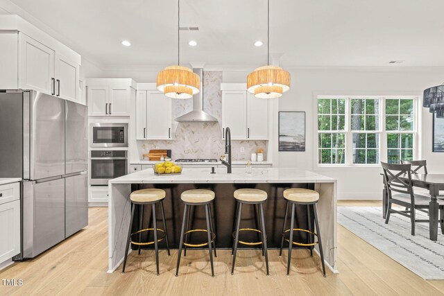 525 Kings Lake Way, Durham, NC 27703 - kitchen featuring appliances with stainless steel finishes, wall chimney exhaust hood, backsplash, crown molding, and white cabinetry