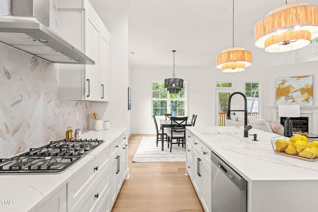 525 Kings Lake Way, Durham, NC 27703 - kitchen featuring stainless steel appliances, wall chimney range hood, light wood-type flooring, and white cabinetry