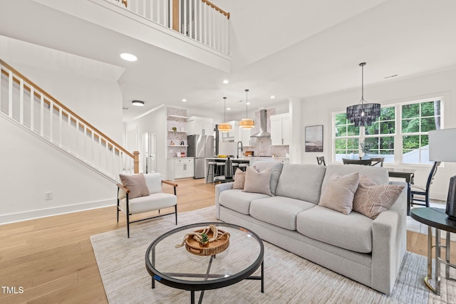 525 Kings Lake Way, Durham, NC 27703 - living area with a chandelier, stairs, light wood-style floors, recessed lighting, and a towering ceiling