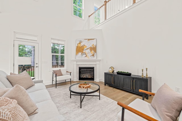 525 Kings Lake Way, Durham, NC 27703 - living area featuring a glass covered fireplace, light wood-style floors, and a high ceiling