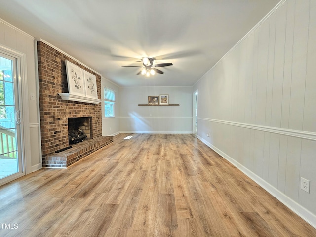 112 Saddletree Rd, Oxford, NC 27565 - unfurnished living room with light wood-style flooring, a ceiling fan, ornamental molding, and a brick fireplace