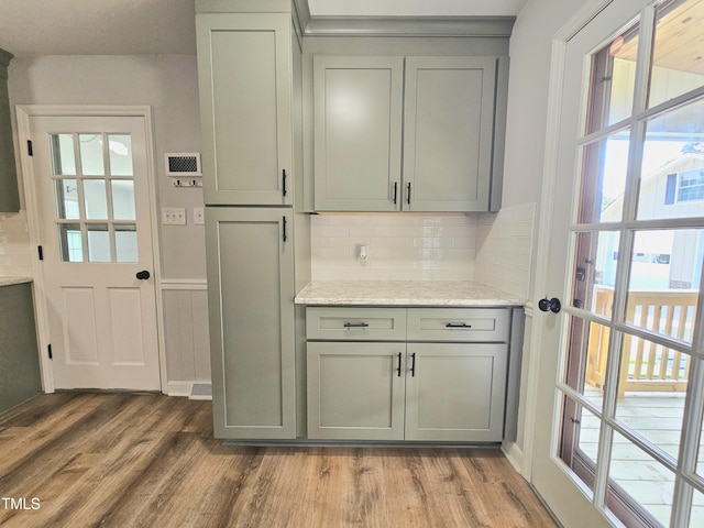 112 Saddletree Rd, Oxford, NC 27565 - kitchen featuring gray cabinets, light wood-type flooring, backsplash, and light stone counters