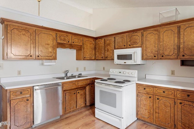 34 Scotts Creek Run, Angier, NC 27501 - kitchen with white appliances, brown cabinets, lofted ceiling, light wood-type flooring, and light countertops