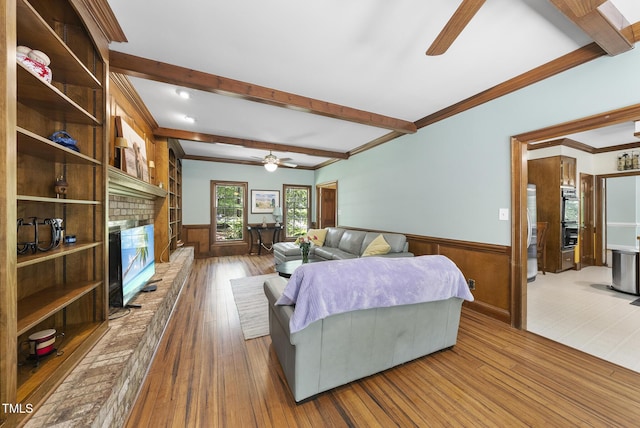 821 Ascot Ln, Raleigh, NC 27615 - living room featuring ceiling fan, beamed ceiling, hardwood / wood-style floors, wainscoting, and a fireplace