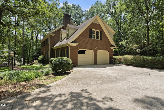 821 Ascot Ln, Raleigh, NC 27615 - view of side of home with brick siding, an attached garage, driveway, and a chimney