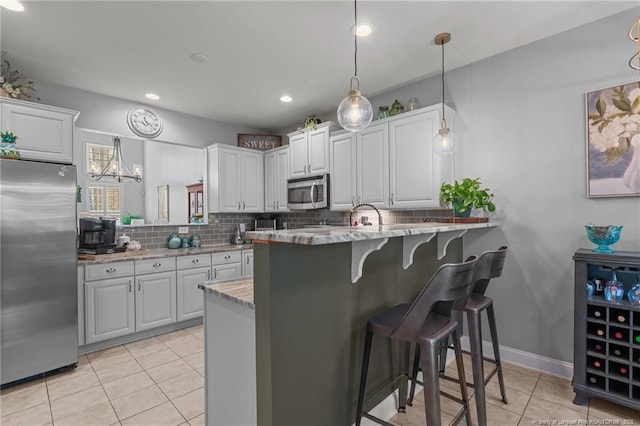 82 Pine Hawk Dr, Spring Lake, NC 28390 - kitchen with stainless steel appliances, light tile patterned floors, backsplash, a kitchen bar, and a peninsula