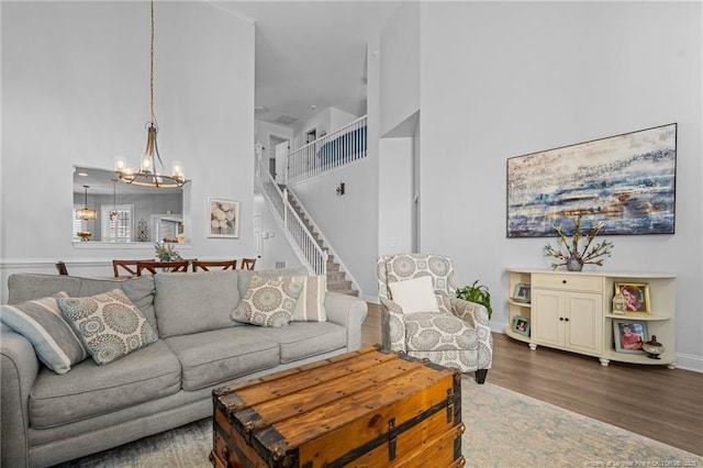 82 Pine Hawk Dr, Spring Lake, NC 28390 - living area featuring a towering ceiling, a chandelier, wood finished floors, and stairs