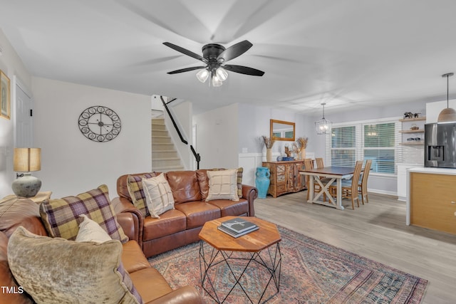 8801 Valley Hill Ct, Apex, NC 27539 - living room with light wood-style floors, ceiling fan, stairway, and a chandelier