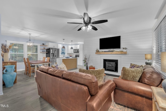 8801 Valley Hill Ct, Apex, NC 27539 - living room with a large fireplace, a ceiling fan, light wood-type flooring, and a chandelier