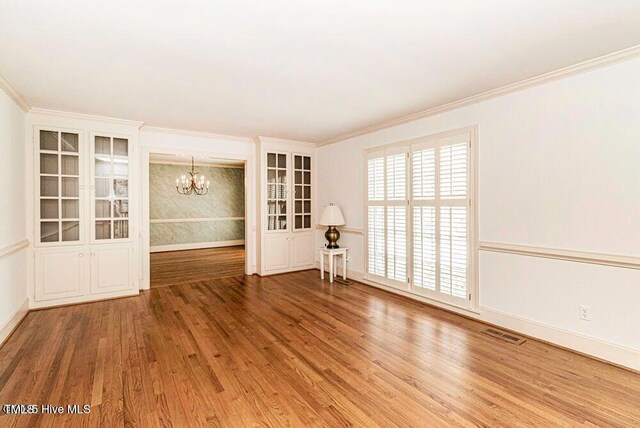 322 Gravley Dr, Rocky Mount, NC 27804 - empty room featuring a chandelier, wood finished floors, and crown molding