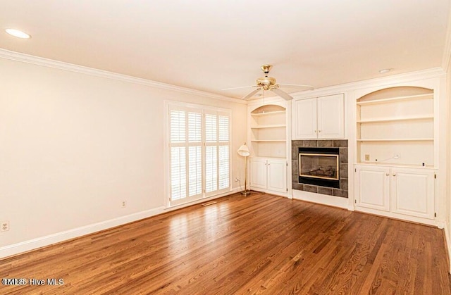 322 Gravley Dr, Rocky Mount, NC 27804 - unfurnished living room featuring a tile fireplace, wood finished floors, ornamental molding, a ceiling fan, and built in shelves