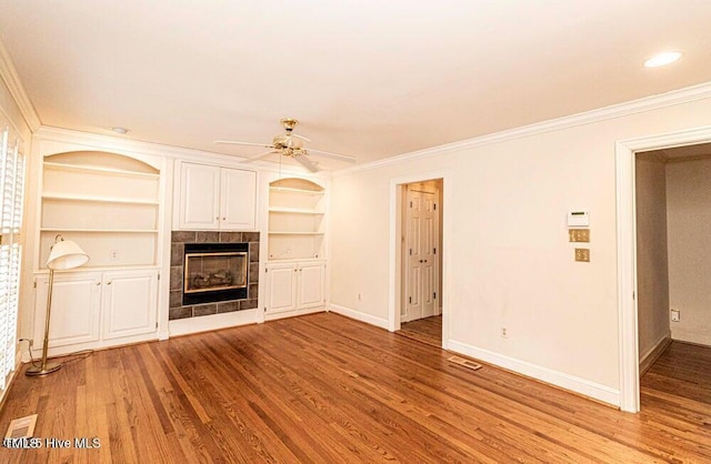 322 Gravley Dr, Rocky Mount, NC 27804 - unfurnished living room featuring a fireplace, a ceiling fan, wood finished floors, crown molding, and built in features