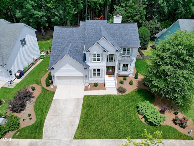 8841 Deerland Grove Dr, Raleigh, NC 27615 - traditional-style house with a shingled roof, a garage, a chimney, concrete driveway, and a front lawn