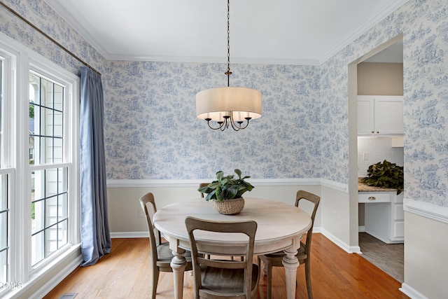 8841 Deerland Grove Dr, Raleigh, NC 27615 - dining space with light wood-type flooring, a chandelier, and crown molding
