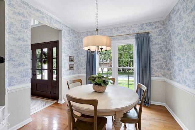 8841 Deerland Grove Dr, Raleigh, NC 27615 - dining space featuring light wood-type flooring, a chandelier, wallpapered walls, and wainscoting