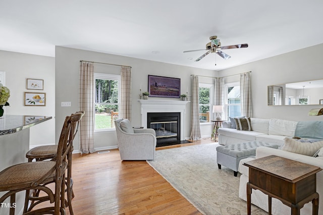 8841 Deerland Grove Dr, Raleigh, NC 27615 - living room featuring a ceiling fan, a fireplace with flush hearth, and light wood finished floors