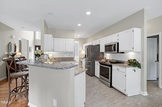 8841 Deerland Grove Dr, Raleigh, NC 27615 - kitchen featuring stainless steel appliances, a peninsula, light stone countertops, tasteful backsplash, and recessed lighting