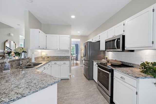 8841 Deerland Grove Dr, Raleigh, NC 27615 - kitchen with appliances with stainless steel finishes, light stone counters, tasteful backsplash, white cabinets, and recessed lighting