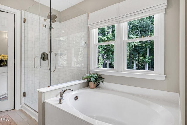 8841 Deerland Grove Dr, Raleigh, NC 27615 - bathroom featuring a garden tub, a shower stall, and tile patterned floors