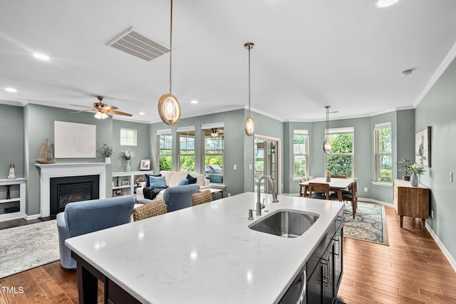 1523 Anthology Dr, Durham, NC 27703 - kitchen featuring crown molding, dark wood-type flooring, recessed lighting, hanging light fixtures, and a center island with sink
