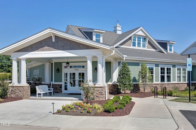 1523 Anthology Dr, Durham, NC 27703 - view of front of property with covered porch, stone siding, a shingled roof, and french doors