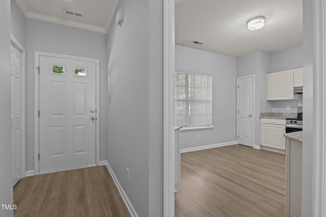 4406 Still Pines Dr, Raleigh, NC 27613 - entryway with wood finished floors, crown molding, and a textured ceiling