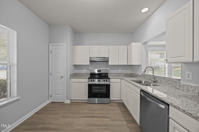 4406 Still Pines Dr, Raleigh, NC 27613 - kitchen featuring stainless steel appliances, white cabinets, dark wood-style flooring, under cabinet range hood, and a textured ceiling