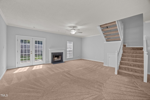 4406 Still Pines Dr, Raleigh, NC 27613 - unfurnished living room with carpet, crown molding, a ceiling fan, stairs, and french doors