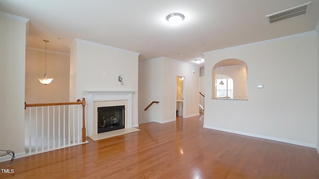 5916 Longeria Ct, Raleigh, NC 27612 - unfurnished living room featuring wood finished floors, ornamental molding, a fireplace, and arched walkways