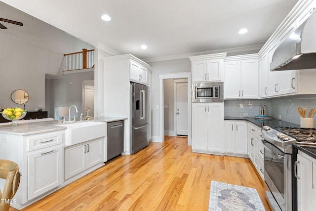 532 Joe Collins Rd, Lillington, NC 27546 - kitchen with wall chimney range hood, stainless steel appliances, a peninsula, ceiling fan, and white cabinetry