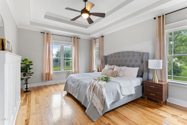 532 Joe Collins Rd, Lillington, NC 27546 - bedroom featuring multiple windows, light wood-type flooring, a raised ceiling, ornamental molding, and a ceiling fan