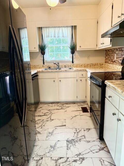 120 W Front St, Oxford, NC 27565 - kitchen with black appliances, under cabinet range hood, light marble finish floors, light stone counters, and white cabinetry