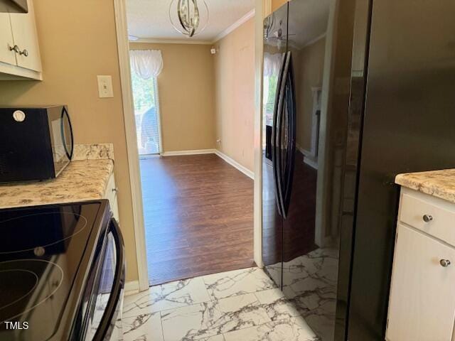 120 W Front St, Oxford, NC 27565 - kitchen featuring black appliances, ornamental molding, white cabinetry, and light marble finish floors
