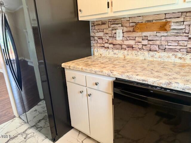 120 W Front St, Oxford, NC 27565 - kitchen with dishwasher, light marble finish flooring, white cabinets, and freestanding refrigerator