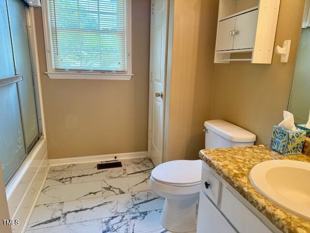 120 W Front St, Oxford, NC 27565 - full bathroom featuring marble look tile flooring, vanity, and bath / shower combo with glass door