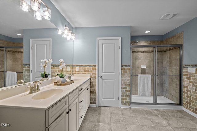 7 Faircroft Ct, Durham, NC 27703 - full bathroom featuring double vanity, a stall shower, wainscoting, and tile walls