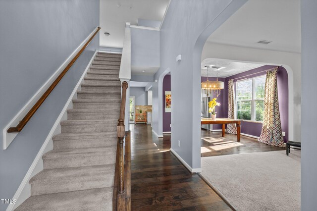 7 Faircroft Ct, Durham, NC 27703 - staircase with arched walkways, wood finished floors, and a chandelier